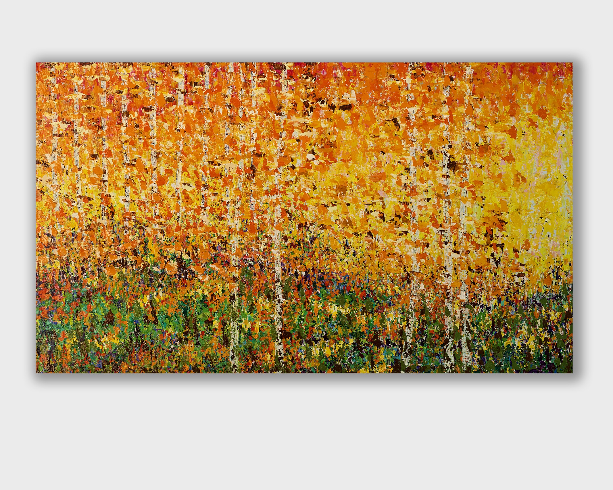 large abstract oil painting in warm yellow, orange and ochre, inspired by falling leaves, hidden tree trunks and the luminous atmosphere of an autumn forest by Pia Andersen. Here on a white wall